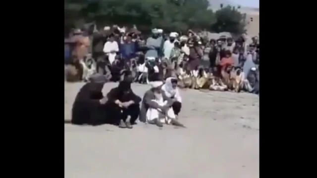 Afghani man beating a defenseless woman covered in a sheet